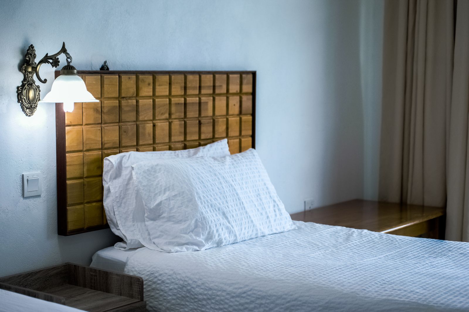 Hotel guestroom with a bed and nightstand